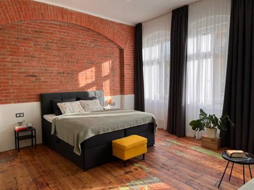 a bedroom with a bed and a brick wall at CARLS AUTHENTIC B&B in Karlovy Vary