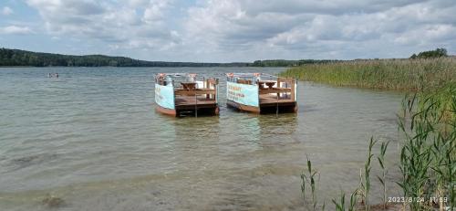 two boats sitting in the water on a lake at Kaszuby Dom W Wielu in Wiele