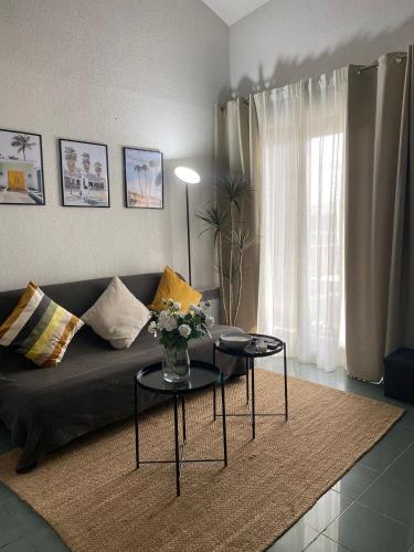 - un salon avec un canapé et deux tables dans l'établissement Le Duplex au centre de Toulouse - Self check In, à Toulouse