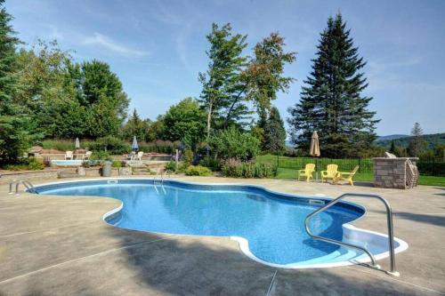 a swimming pool in the middle of a yard at Cozy Chalet on the 9th Hole La Bête Pool Golf in Mont-Tremblant