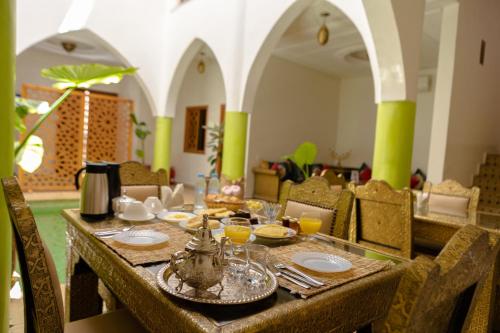 a dining room with a table with food on it at Riad Petite Rose in Marrakesh
