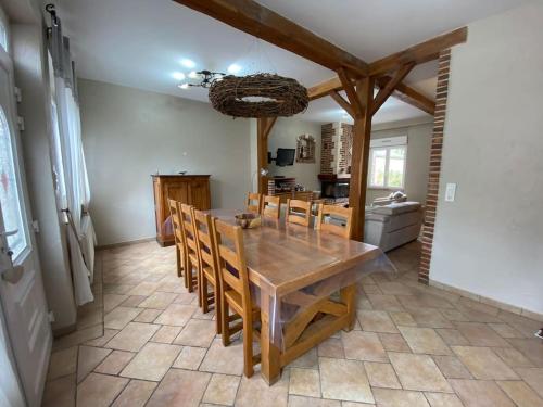 une salle à manger avec une table et des chaises en bois dans l'établissement Maison Au champ du souvenir 5 chambres 8 personnes, à Bécordel-Bécourt