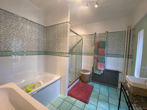 a bathroom with a tub and a sink at Maison. Au champ du souvenir. 8 personnes. 