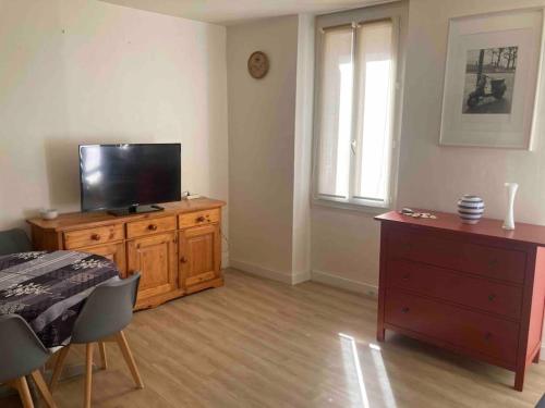 uma sala de estar com uma televisão numa cómoda de madeira e uma cómoda em T2 idéalement placé - entre vieux port et plage em Marselha