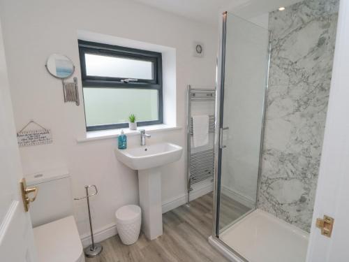 a bathroom with a sink and a shower at Riverside House in Scarborough