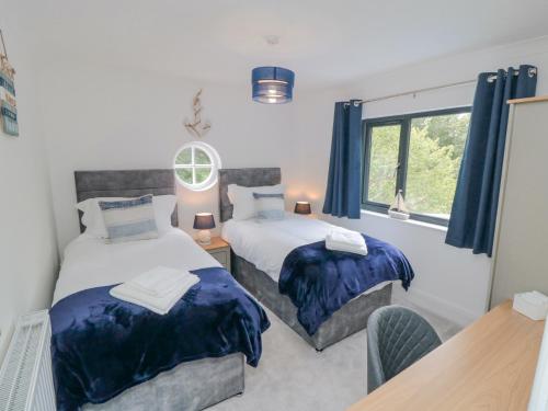 a bedroom with two beds and a table and a window at Riverside House in Scarborough