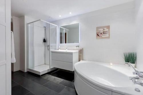 La salle de bains blanche est pourvue d'un lavabo et d'une douche. dans l'établissement Modern apartment in Akureyri, Iceland, à Akureyri