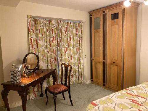 a bedroom with a desk and a mirror and a bed at Self Catering Apartment- 11A Westbourne Place in Cobh