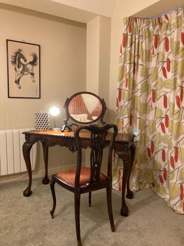 a desk with a chair and a table with a mirror at Self Catering Apartment- 11A Westbourne Place in Cobh