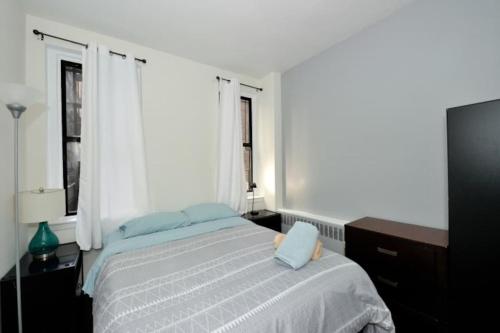 a bedroom with a bed with blue pillows on it at Beautiful 2BR/1BA in Heart of NYC in New York