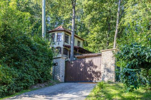 a house with a gate and a garage at Kőszikla Vendégház a csendes pihenésre vágyóknak! in Kismaros