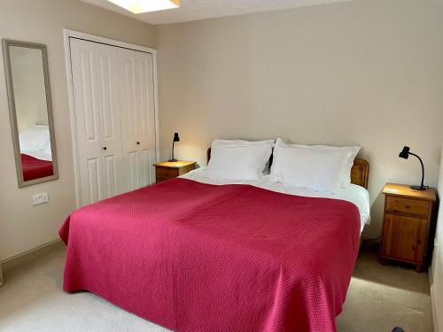 een slaapkamer met een groot bed en een rode deken bij Aleberry Bed and Breakfast in Lewes
