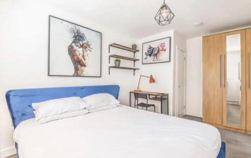 a bedroom with a large white bed and a desk at Egham Contemporary Stylish Three Bedroom Apartment in Egham