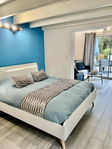 une chambre avec un lit et un mur bleu dans l'établissement Maisonnette de standing à 200m de la plage de Santa Giulia, à Porto-Vecchio