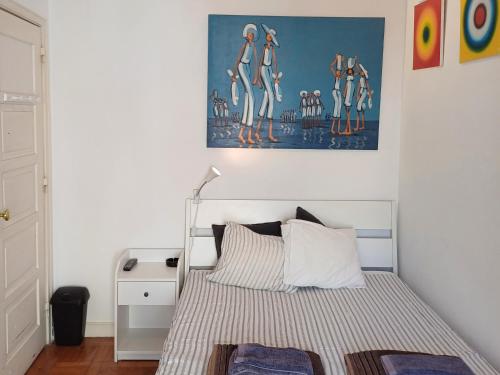 1 dormitorio con 1 cama y una pintura en la pared en Amoreira Room, en Lisboa