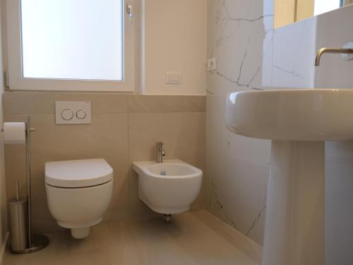 a bathroom with a white toilet and a sink at EMPATIA PESCARA CENTRO in Pescara