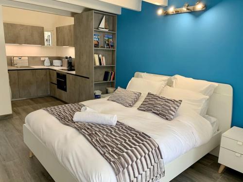 - une chambre avec un grand lit blanc et un mur bleu dans l'établissement Maisonnette de standing à 200m de la plage de Santa Giulia, à Porto-Vecchio