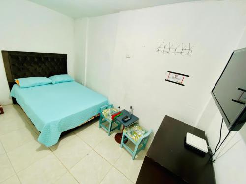um pequeno quarto com uma cama e uma televisão em Hostal Badillo SV em Cartagena das Índias