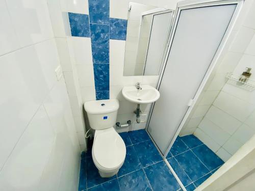 a bathroom with a toilet and a sink at Hostal Badillo SV in Cartagena de Indias