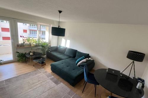 uma sala de estar com um sofá verde e uma mesa em Helle Oase am Zürichsee * * * * * em Freienbach