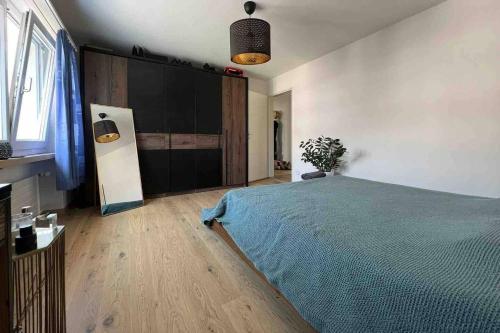 um quarto com uma cama com um cobertor azul em Helle Oase am Zürichsee * * * * * em Freienbach