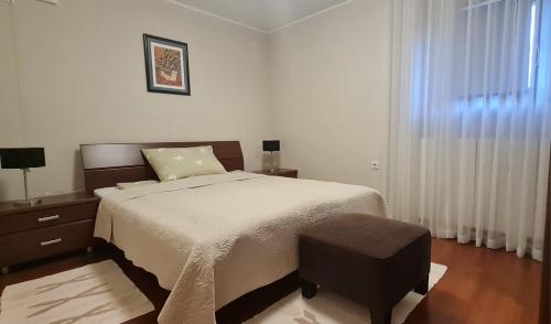 een slaapkamer met een groot bed en een raam bij Apartman Neli in Delnice