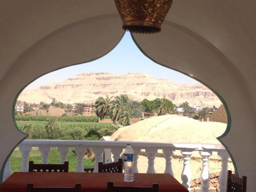 a table with a view of the desert from a window at Cleopatra Hotel Luxor in Luxor