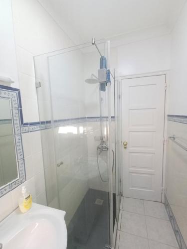 a bathroom with a shower and a toilet and a sink at Amoreira Room I and II in Lisbon