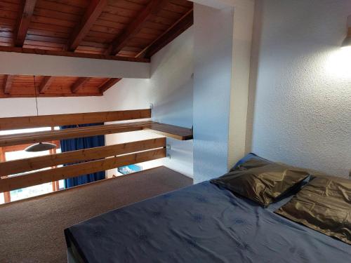 une chambre avec un lit dans une pièce avec des plafonds en bois dans l'établissement Agréable duplex 6 pers, au dernier étage, 2 balcons, animaux admis - FR-1-411-731, à Bourg-Saint-Maurice