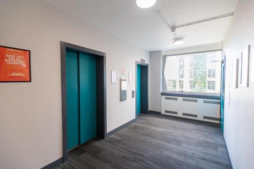an office hallway with green doors and a window at easyHotel Croydon in Croydon