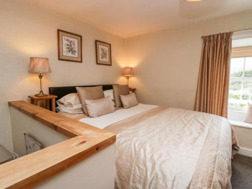 a bedroom with a large bed and a window at Rusland View in Ulverston