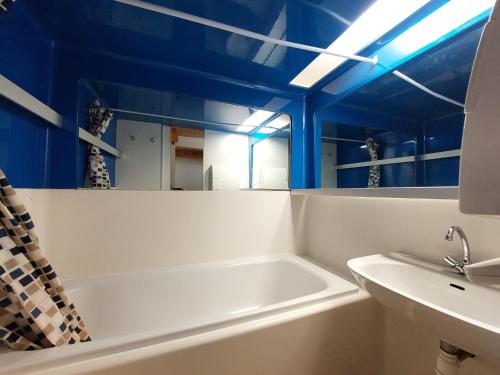 La salle de bains est pourvue d'une baignoire, d'un lavabo et de plafonds bleus. dans l'établissement Duplex 6 pers à Arc 1800, proche pistes Charmettoger, balcon, TV, Wifi - FR-1-411-798, à Bourg-Saint-Maurice