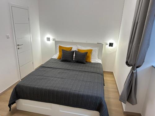 Un dormitorio con una cama grande con almohadas amarillas. en Apartment VidRi, en Rijeka