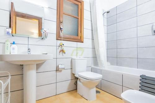 a bathroom with a toilet and a sink and a tub at Mountain View Villa in Playa Blanca