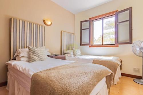 a room with three beds and a window at Mountain View Villa in Playa Blanca