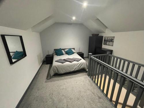 a bedroom with a bed with blue pillows on it at 3 bedroom apartment in the village of Whitwell in Worksop
