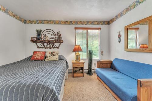 a bedroom with a blue bed and a couch at 7 Springs Ski & Mountain Adventure Condo condo in Champion