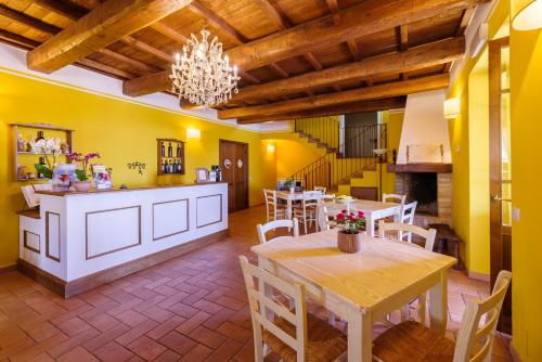 a dining room with yellow walls and a table and chairs at Agriturismo Le Vigne in Foligno