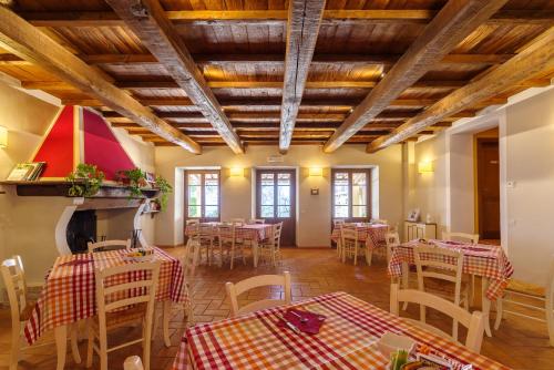 una stanza con tavoli, sedie e soffitti in legno di Agriturismo Le Vigne a Foligno