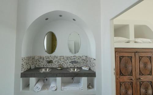 La salle de bains est pourvue de 2 lavabos et de 2 miroirs. dans l'établissement Domaine de la Bedosse, à Alès