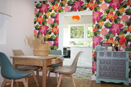 a kitchen with a table and chairs with a floral wall at Loft La buena vida in Peñaranda de Duero