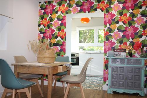 - une cuisine avec une table et des chaises avec un mur fleuri dans l'établissement Loft La buena vida, à Peñaranda de Duero