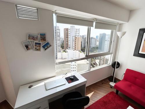 baño con sofá rojo y ventana grande en Apartamento exclusivo y céntrico en Lima Moderna, en Lima