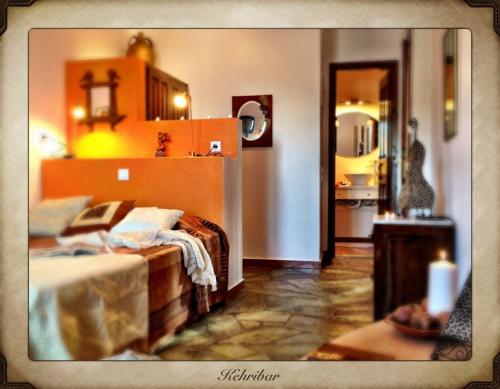 a bedroom with a bed and a kitchen in the background at Aperanto Galazio in Skopelos Town