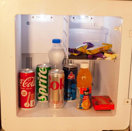 um frigorífico aberto com refrigerante e bebidas em Galaxy Golden Fortune Hotel em Bangalore