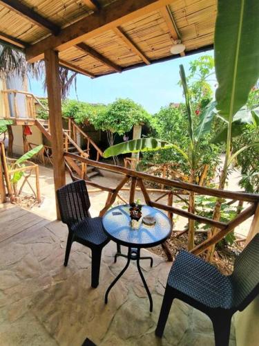un patio con 2 sillas y una mesa en un porche en Bright Bungalow 3 -Close to Ocean, en Zorritos