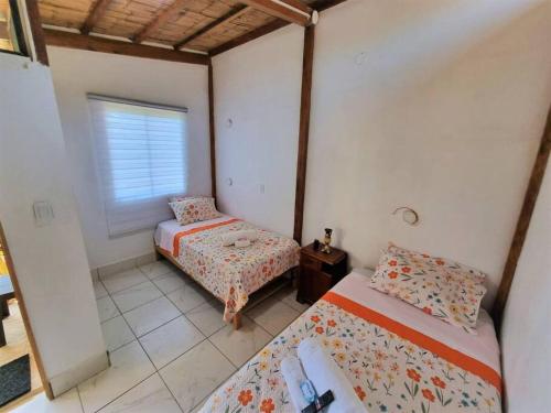 1 dormitorio con 2 camas y ventana en Bright Bungalow 3 -Close to Ocean, en Zorritos