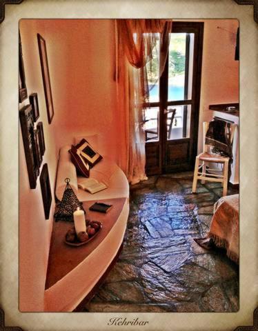 a room with a couch and a candle and a window at Aperanto Galazio in Skopelos Town