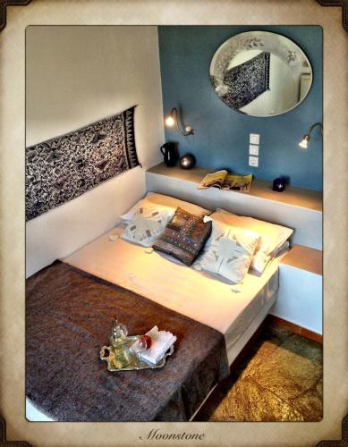 a bedroom with a large bed with a mirror at Aperanto Galazio in Skopelos Town