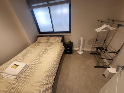 a small bedroom with a bed and a window at Entire Reigate Apartment hosted by Pius in Reigate